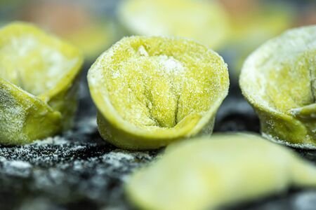 Raw green dumplings or vareniks, with green dough from leaf juice traditional Russian and Ukrainian food, close upの写真素材