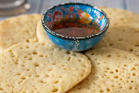 Moroccan pancakes Baghrir or Beghrir or crapes can also be named Lahoh with 1000 holes served with honey on a blue grey wooden table, close upの写真素材