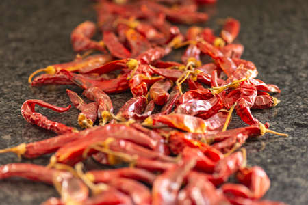 Dried red chili or chilli cayenne pepper on black marble background, close up, selective focusの写真素材