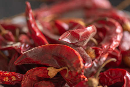 Dried red chili or chilli cayenne pepper on black marble background, close up