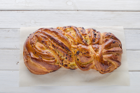 Bun with raisins and cottage cheese on a white wooden backgroundの写真素材