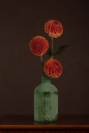 Dahlias in a vase on a wooden tableの写真素材