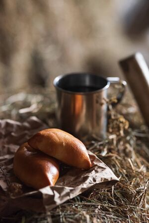 Fresh homemade meat patty cakes and steel cup on hayloft. Picnic. Close upの写真素材