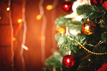 Christmas tree with warm and luminosity blurred background. Holiday design with decorative balls.の写真素材