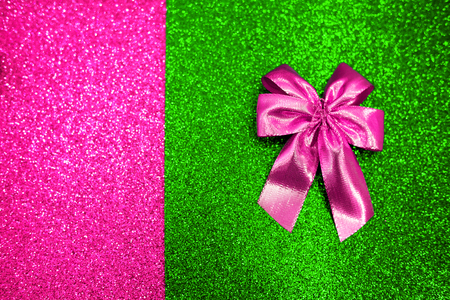 Plastic pink atlas bow on the and UFO green and purple trend colorful sparcling background. Fashion concept.の写真素材