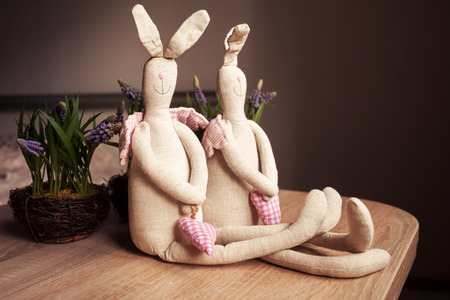 Happy couple handmade linen toys rabbits with red hearts. Easter and Valentine Day holiday concept. Wedding theme.の写真素材