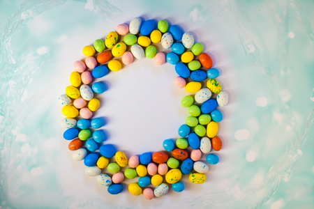 Easter sweet frame from colorful chocolate eggs on white backround. Top view, copyspace for your...