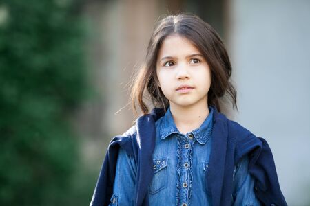 Little girl walking and look on smth. Child dreams and smiles.