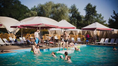 Zaporozhye, Ukraine-August 2018: a pool party in the company of ovoh. funny friends playing volleyball on inflatable boats in the pool in a ride on wakeboarding.のeditorial素材