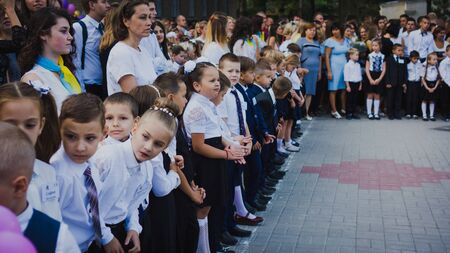 Zaporozhye, Ukraine - September 1, 2018: first-graders stand on a ruler in the open air with teachers and high school students on the ceremonial school line on the day of knowledge.のeditorial素材