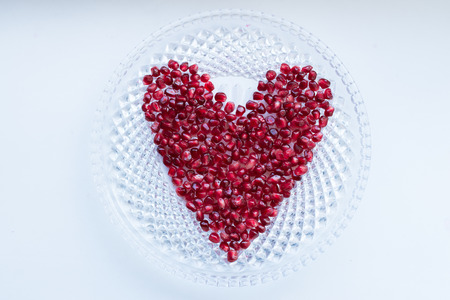 Fresh ripe pomegranate berries in a heart shapeの写真素材