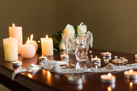 Burning candles with a few roses and perfumeの写真素材