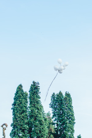 White balloons in the blue skyの写真素材
