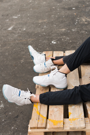 Legs and feet of couple in love in stylish white snickersの写真素材