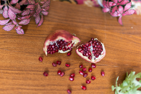 Fresh ripe pomegranate on a wooden table with green leafsの写真素材