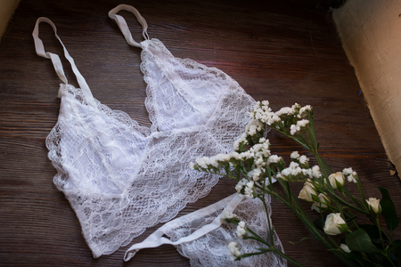 White women's lingerie and white flowers on the wooden windowsillの写真素材