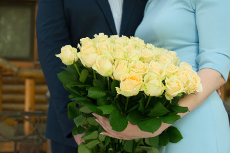 The bouquet of yellow roses in the hands of the bride and groom. Bunch of yellow rosesの写真素材