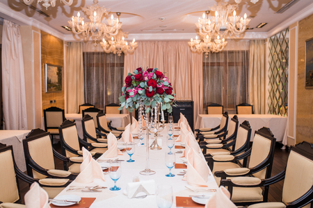 Wedding arrangement with fresh red roses, orchids and eucalyptus on the banquet tableのeditorial素材