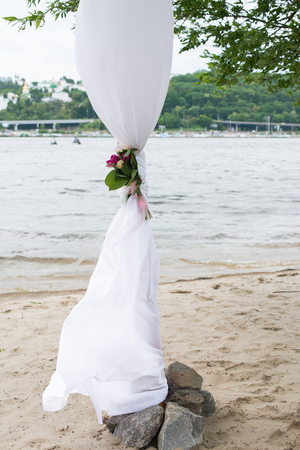 A part of wedding arch with greenery and peonies and river in the background.の写真素材