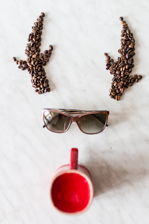 Deer. Horns from coffee beans. Sunglasses. Red cupの写真素材