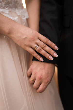 Hands of married couple with golden rings.の写真素材