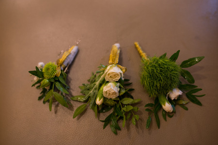 Stylish boutonniere groom and his friends. Three boutonnieres in beige colors on brown backgroundの写真素材