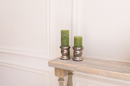Two green thick candles in a silver candlestickの写真素材