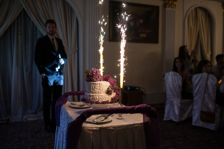 The wedding cake with fireworks stand on the table in restaurantの写真素材