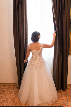 The bride stands near the window with. Weddingの写真素材