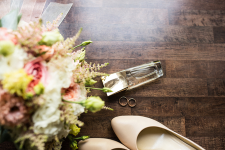 Wedding accessories. Gold perfume, golden rings, wedding shoes and a part of bridal bouquet. Wedding details.の写真素材