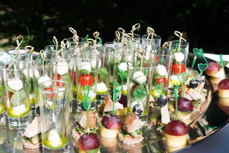 The glasses are filled with snacks: cherry tomato, mozzarellaの写真素材