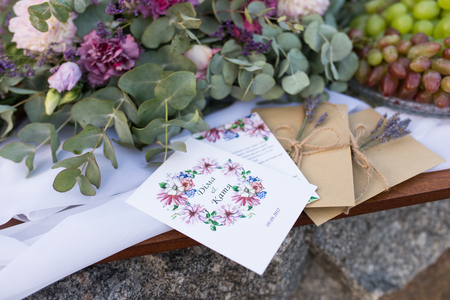 Wedding invitations in the craft envelopes with a bunches of lavender. Wedding concept. Wedding accessories.の写真素材