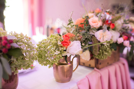 Rustic flower arrangement in a golden vase at a wedding banquet. Table set for an event party or wedding reception.の写真素材