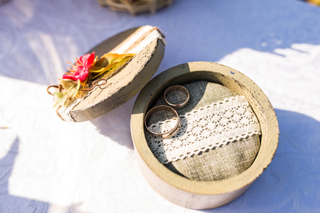 Gold wedding rings in a wooden boxの写真素材