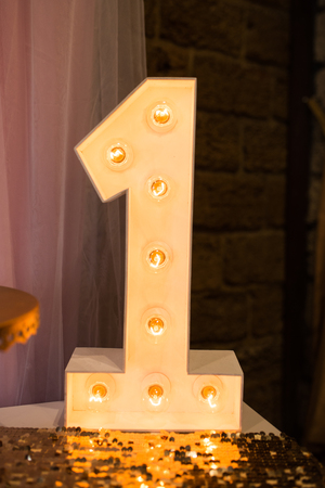Wooden electric light up lamp alphabet in hard font. Number 1. Wooden number 1 with bulbs. First birthdayの写真素材