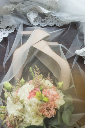 Beige bridal gowns and a bouquet covered with a veil. Wedding details.の写真素材