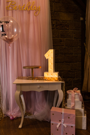 Wooden electric light up on a table. Number 1. Wooden number 1 with bulbs. First birthdayの写真素材