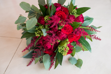 Wedding. Lush bridal Bouquet of red roses and a lot of greeneryの写真素材