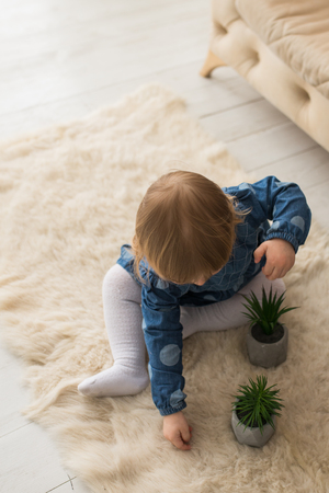 Top view of little girl playing on the floor. A girl with a potato on the floor. View from above.の写真素材