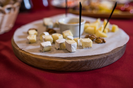 Camembert cheese cut into pieces on a wooden standの写真素材