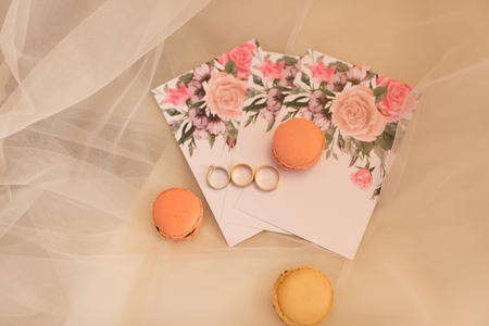 On the wedding invitation lying pastry macaroons and wedding rings. Wedding concept.の写真素材