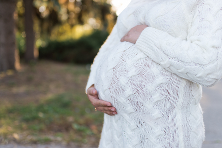 Image of a pregnant woman touching her belly with handsの写真素材