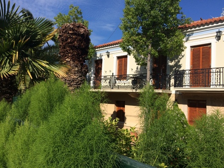 The balconies of the house are hidden in the trees. Little orange villa in a hidden gardenの写真素材