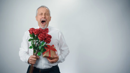 An elderly stylish grandfather with a bouquet of flowers in fashionable clothesの写真素材