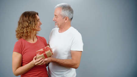 An elderly man makes a gift to his beautiful wife on the anniversaryの写真素材
