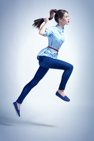 Studio photo in urban style of young woman in a jump.の写真素材