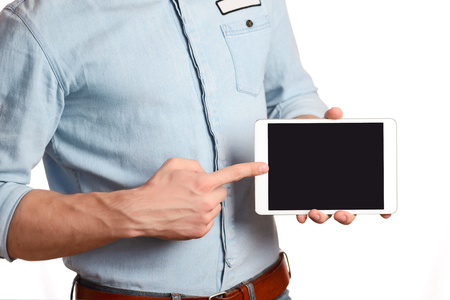 A man in a light blue shirt is holding tablet pc isolated on white, pointing to the screen tablet PCの写真素材