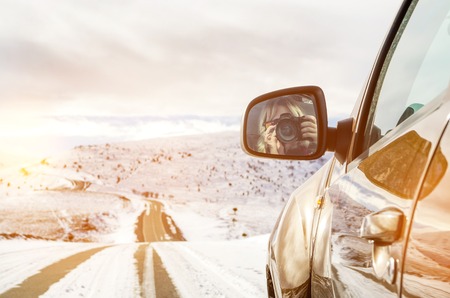 Beautiful girl sitting in an SUV riding in the mountainsの写真素材