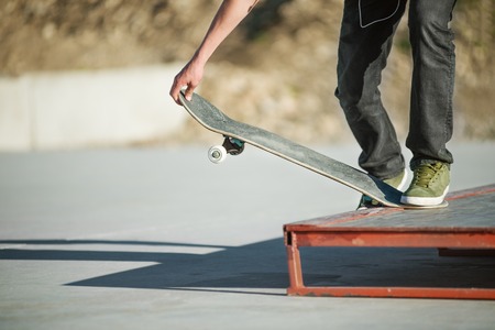 A young guy on a skateboard in a manual on a skatepark on the background of houseの写真素材