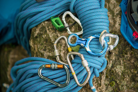 Used equipment for climbing where the rope carbines and climbing slippers lie on a rockの写真素材